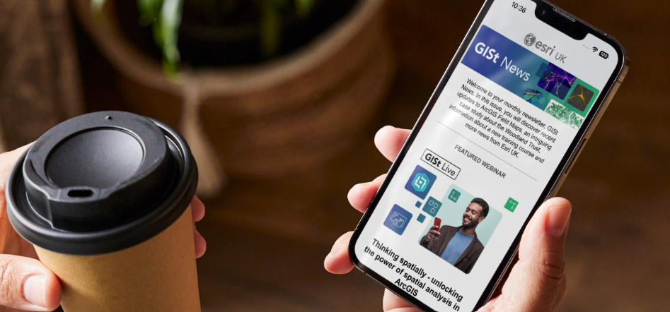 Image of a person holding a phone with the GISt newsletter showing