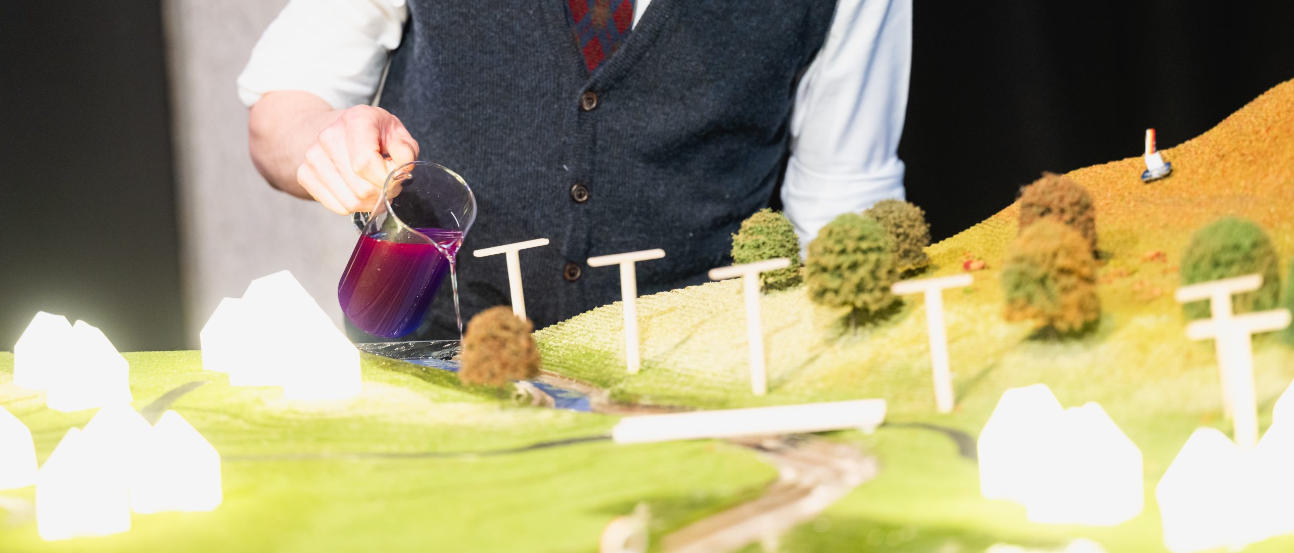Pouring water into the model river to simulate rising water levels.