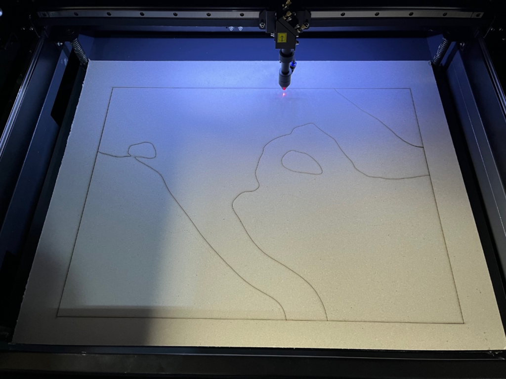 One of the contour layers being cut on the laser cutter.